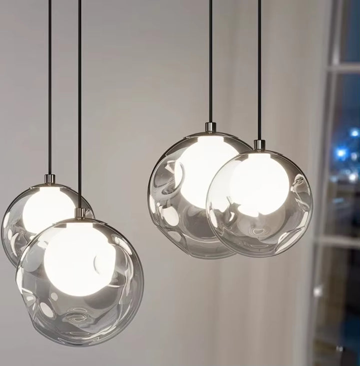 Quatre globes en verre transparent aux cœurs lumineux blancs se dévoilent en gros plan, dans un style design contemporain.