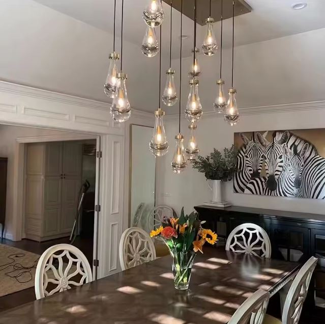 Lustre en gouttes de verre transparent au style contemporain, parfait pour illuminer une élégante salle à manger