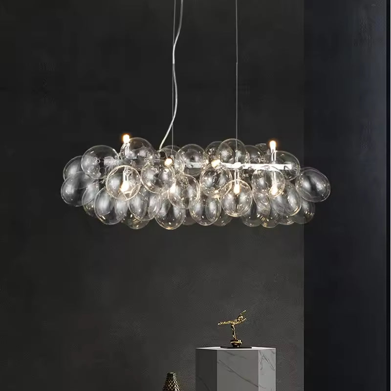 En version linéaire, ce lustre grappe en verre transparent associe bulles lumineuses et design contemporain sophistiqué