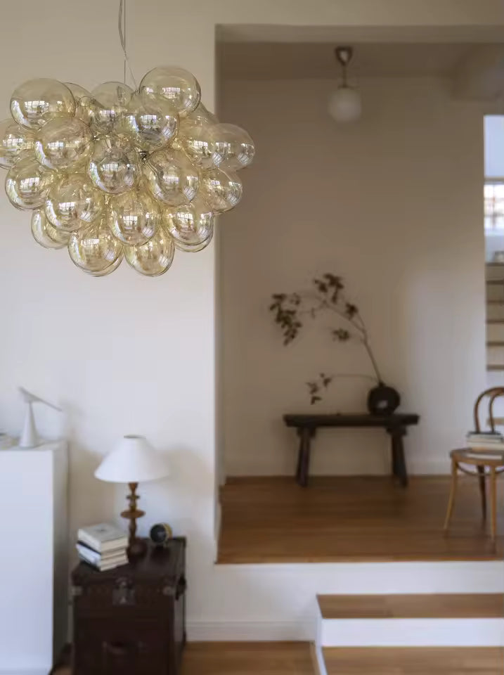 Dans un intérieur minimaliste, ce lustre grappe en verre champagne apporte un volume aérien, organique et élégant