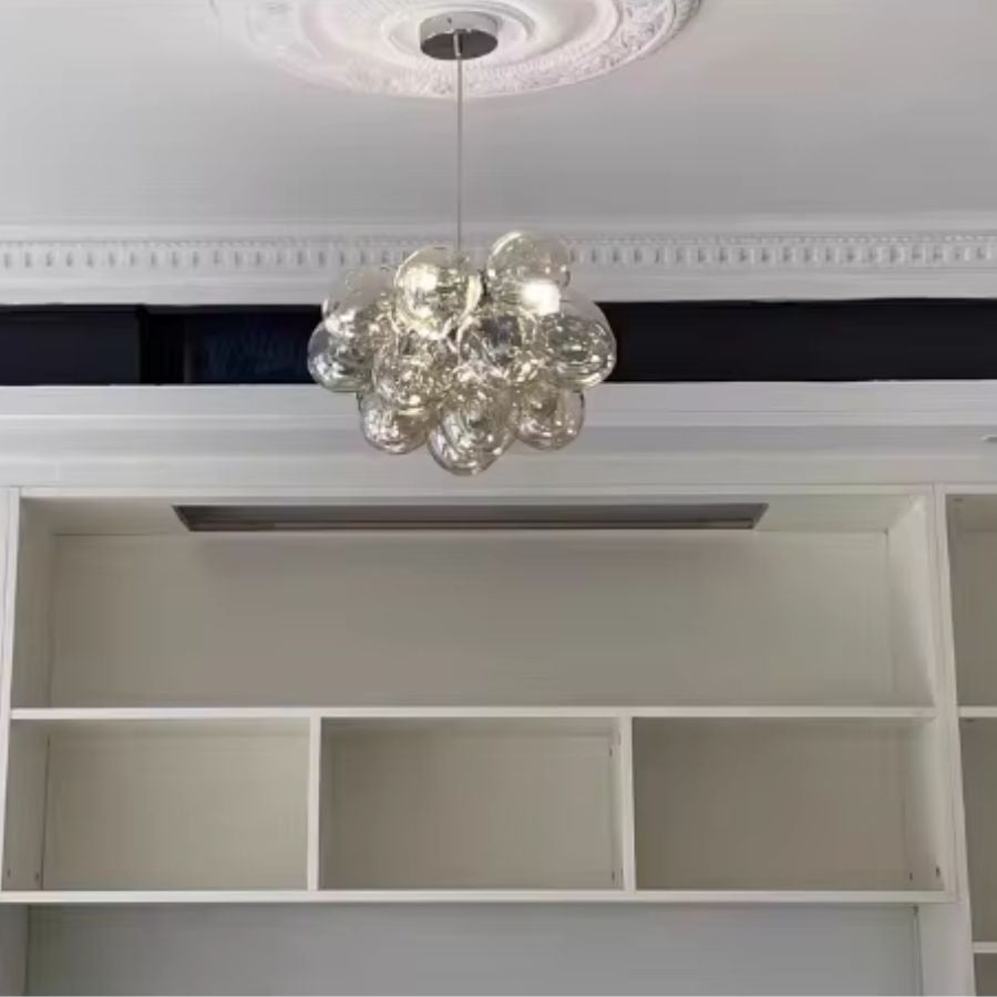 Petit lustre grappe en verre champagne suspendu sous une rosace décorative, au style élégant et contemporain