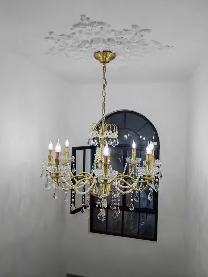 Suspendu par une chaîne dorée, ce lustre laiton vintage à pampilles en cristal apporte une touche classique et raffinée.