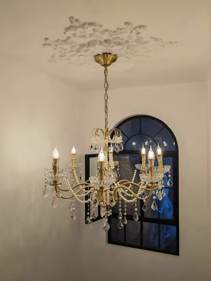 Dans un intérieur au charme ancien, un lustre laiton vintage à pampilles en cristal illumine l'espace avec élégance.