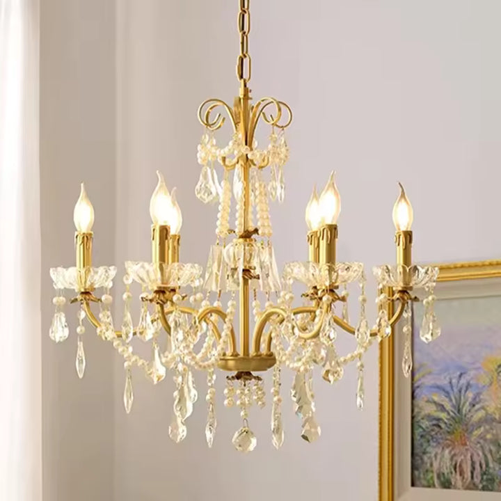Lustre laiton vintage à bras courbés, décoré de guirlandes de cristal et de pampilles scintillantes au style ancien.