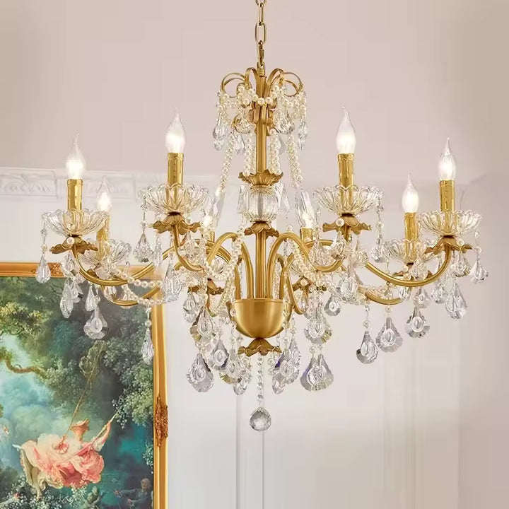 Orné de pampilles en cristal et de bras dorés, ce lustre laiton vintage illumine un intérieur au charme baroque.