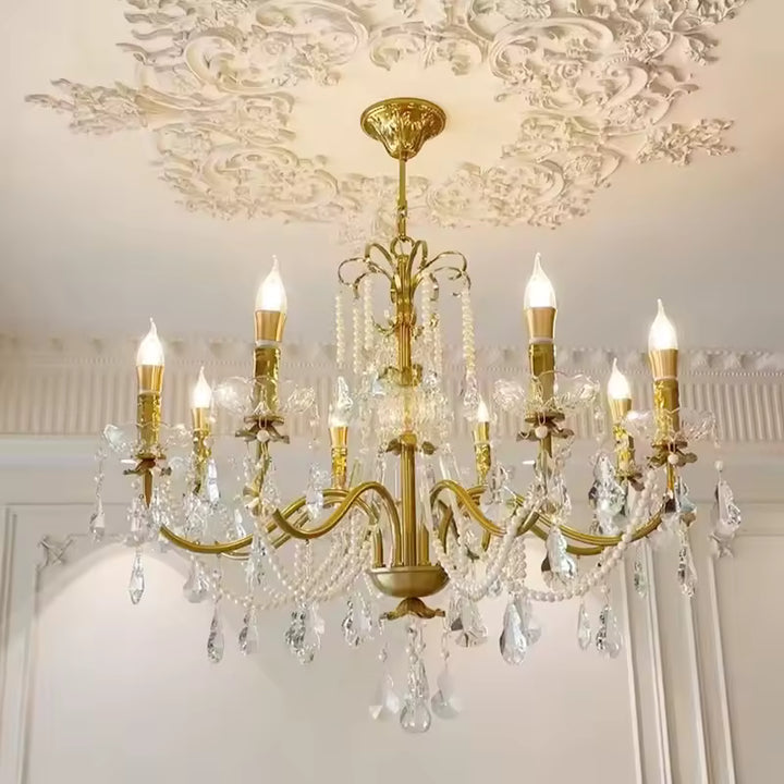 Sous un plafond ornementé, ce lustre laiton vintage à pampilles en cristal révèle une élégance classique et raffinée.