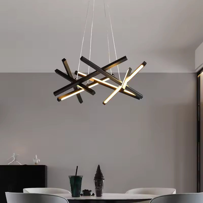Au-dessus d'une table à manger, une suspension noire aux barres LED croisées apporte une touche industrielle et graphique.