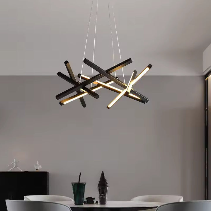 Au-dessus d'une table à manger, une suspension noire aux barres LED croisées apporte une touche industrielle et graphique.
