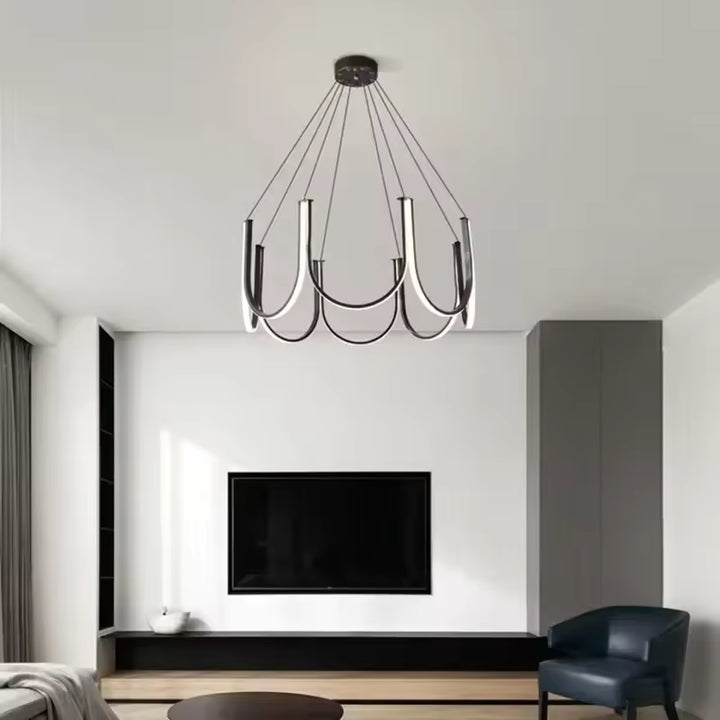 Éclairant un salon contemporain, ce lustre LED noir associe courbes suspendues et lignes graphiques élégantes
