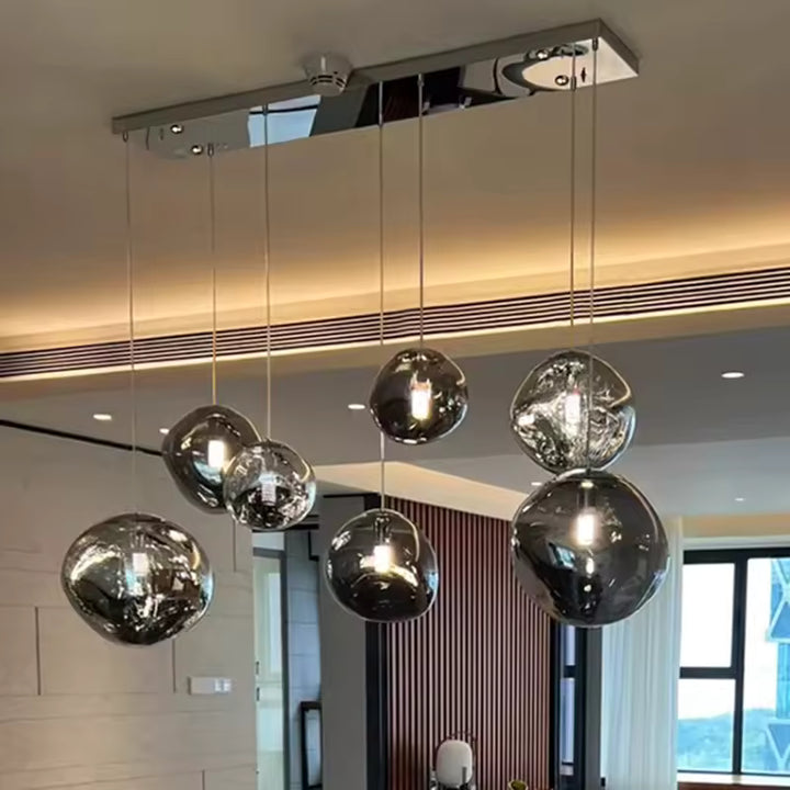 Sept globes en verre fumé aux formes irrégulières composent une suspension sculpturale au style moderne et élégant.