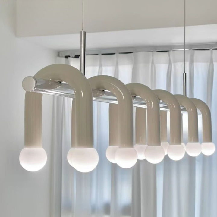 Vue de profil de la suspension linéaire blanche à arches multiples alignées dans un intérieur minimaliste.