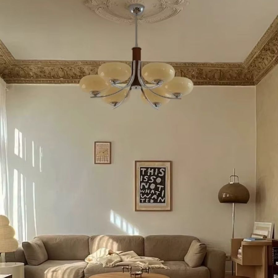 Lustre mid century à 6 abat-jour en verre beige et bras courbes, mis en scène dans un salon au charme vintage élégant