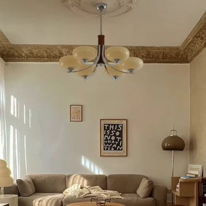 Lustre mid century à 6 abat-jour en verre beige et bras courbes, mis en scène dans un salon au charme vintage élégant