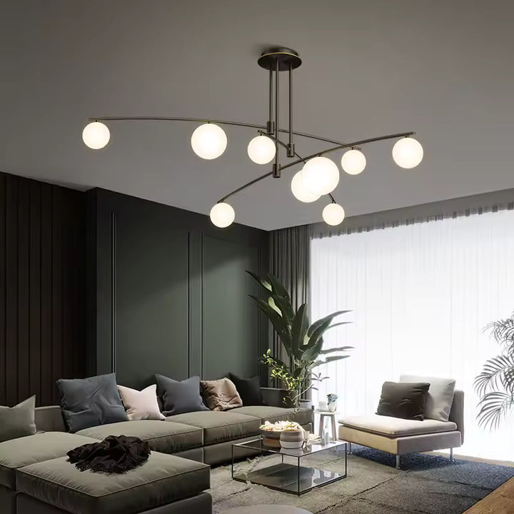 Dans un salon contemporain, lustre aérien aux bras fins entrecroisés et globes lumineux, d'inspiration design italien.