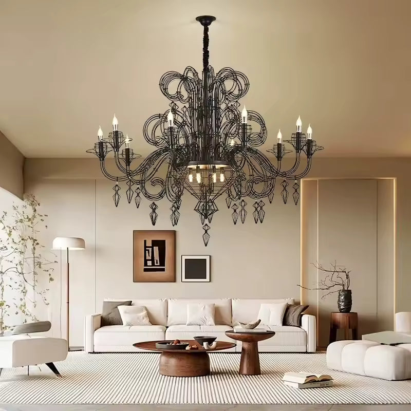 Dans un salon contemporain, lustre noir baroque à volutes métalliques et pampilles ajourées, d'inspiration néoclassique.