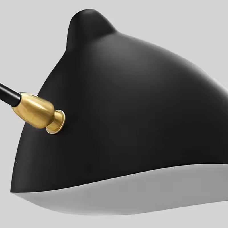 Gros plan sur une coupole noire mate de lustre rétro, avec intérieur blanc et raccord doré, aux finitions industrielles élégantes.