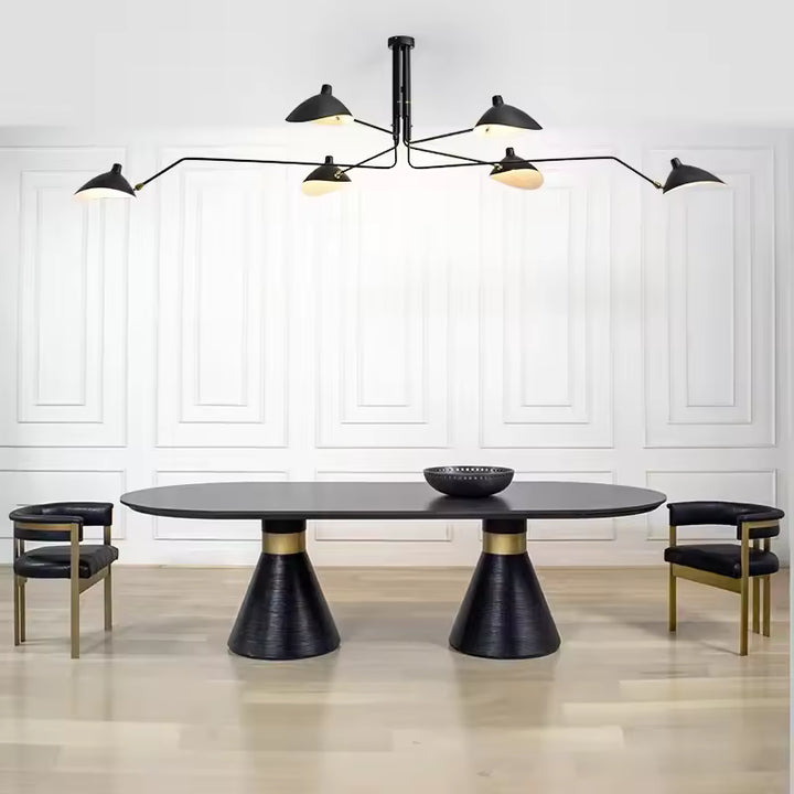 Un lustre noir à six coupoles et bras étirés  domine une table contemporaine, mêlant design mid-century et élégance Art déco.