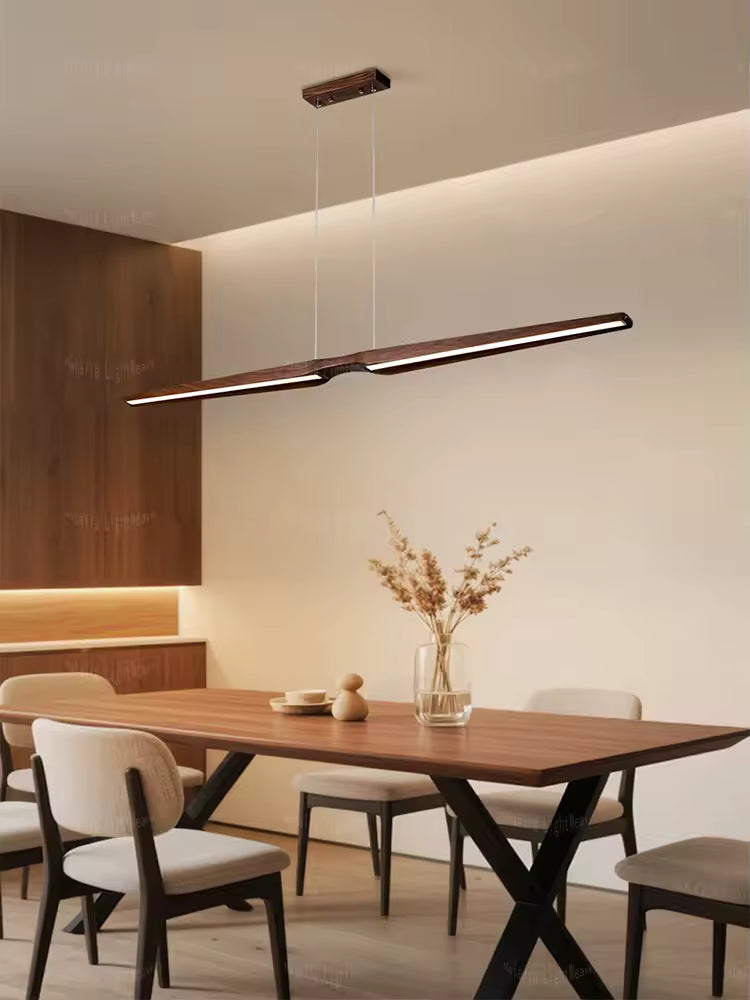 Lustre noyer LED au design japonais épuré, suspendu au-dessus d’une table dans une salle à manger moderne
