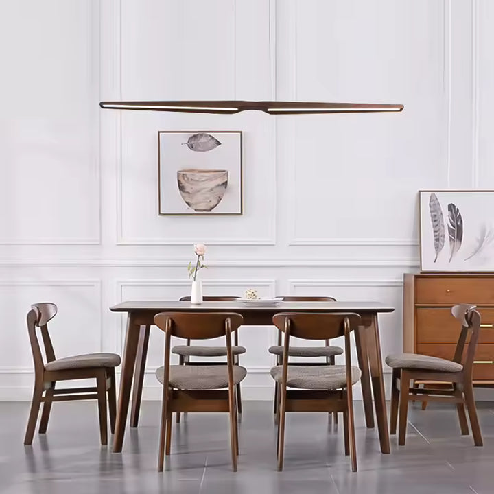 Lustre Noyer LED long au design scandinave épuré, installé au-dessus d’une grande table de salle à manger