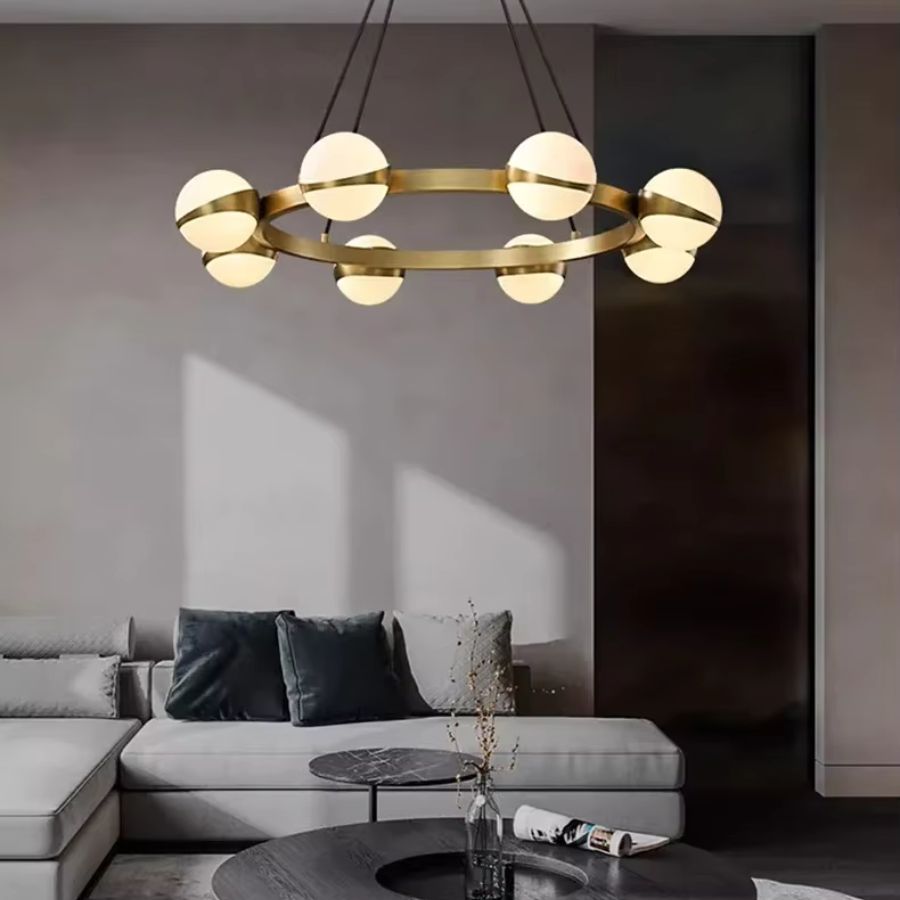 Installé dans un salon contemporain, ce lustre doré à globes lumineux affirme un design graphique et élégant