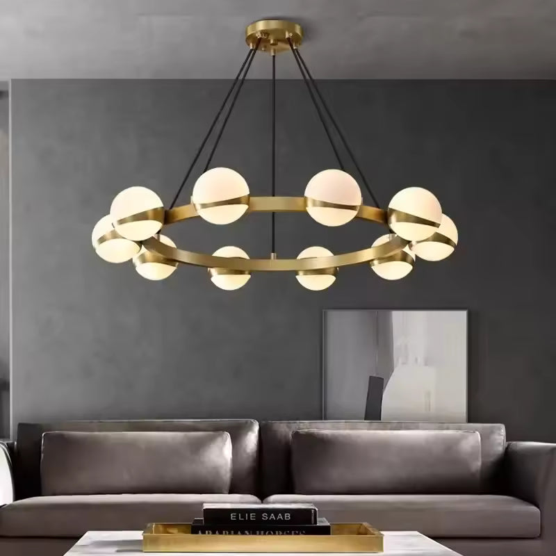 Au-dessus d’un salon contemporain, ce lustre doré à globes lumineux affiche un style design sculptural et élégant