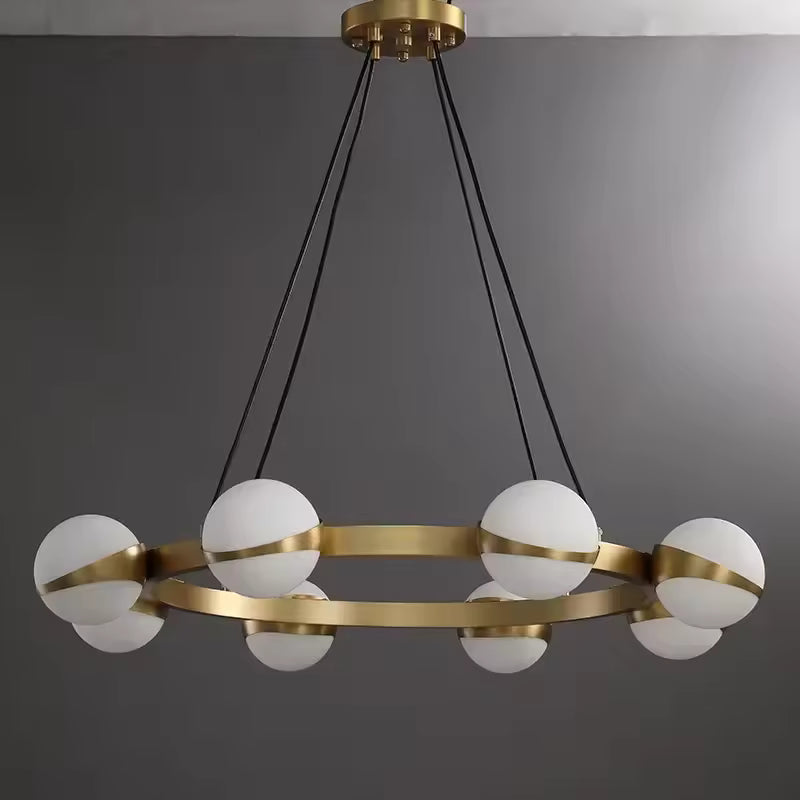 Structure circulaire dorée et globes opalins composent un lustre au design minimaliste, moderne et graphique