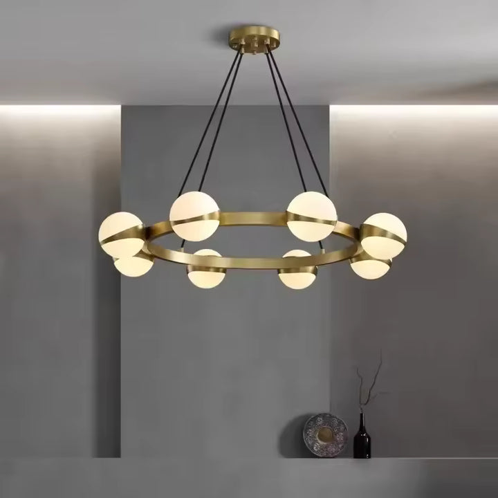 Équilibre graphique entre anneau doré et globes opalins pour un lustre moderne au style minimaliste et élégant