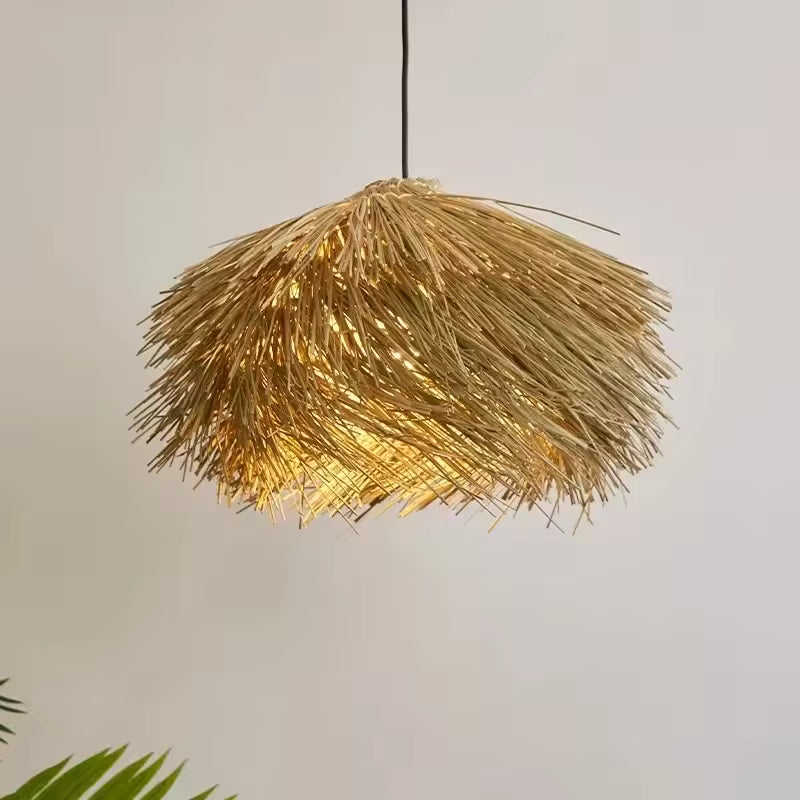 Lustre paille en forme de chapeau diffusant une lumière chaude, au style naturel, bohème et artisanal