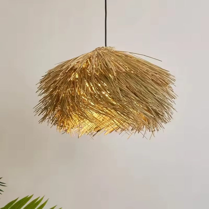 Lustre paille en forme de chapeau diffusant une lumière chaude, au style naturel, bohème et artisanal