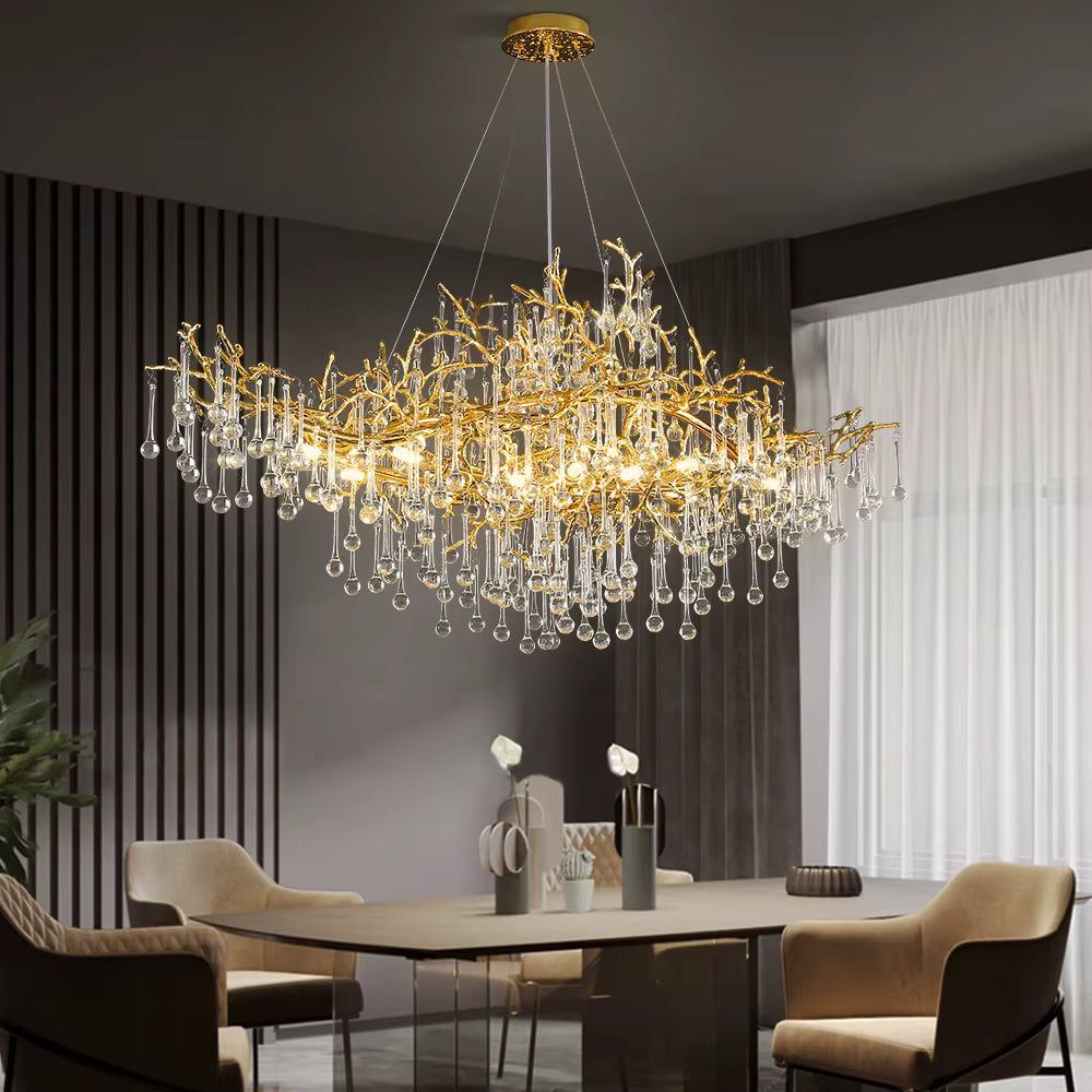 Suspendu au-dessus de la table, ce lustre en cristal aux branches dorées apporte une présence sculpturale à la salle à manger