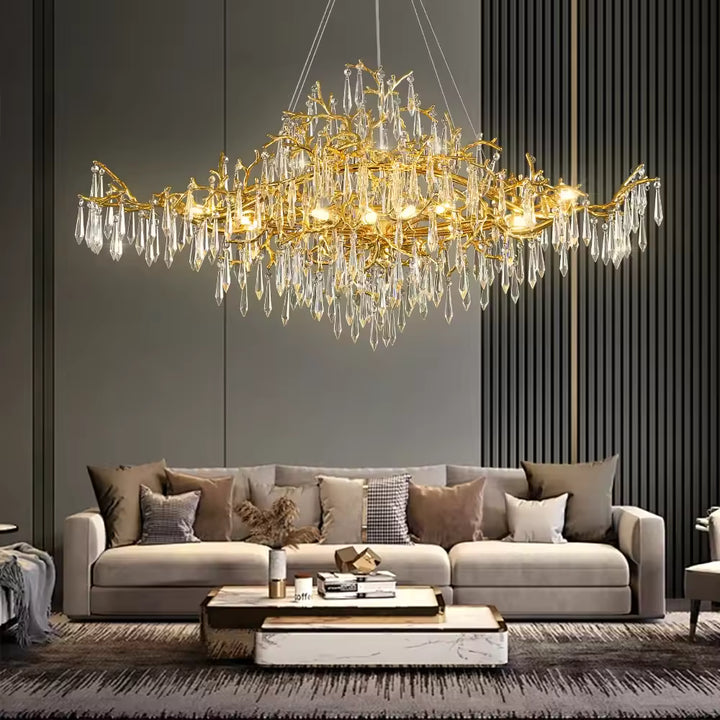 Un luminaire sculptural aux branches dorées et pampilles de cristal illumine avec éclat ce salon contemporain
