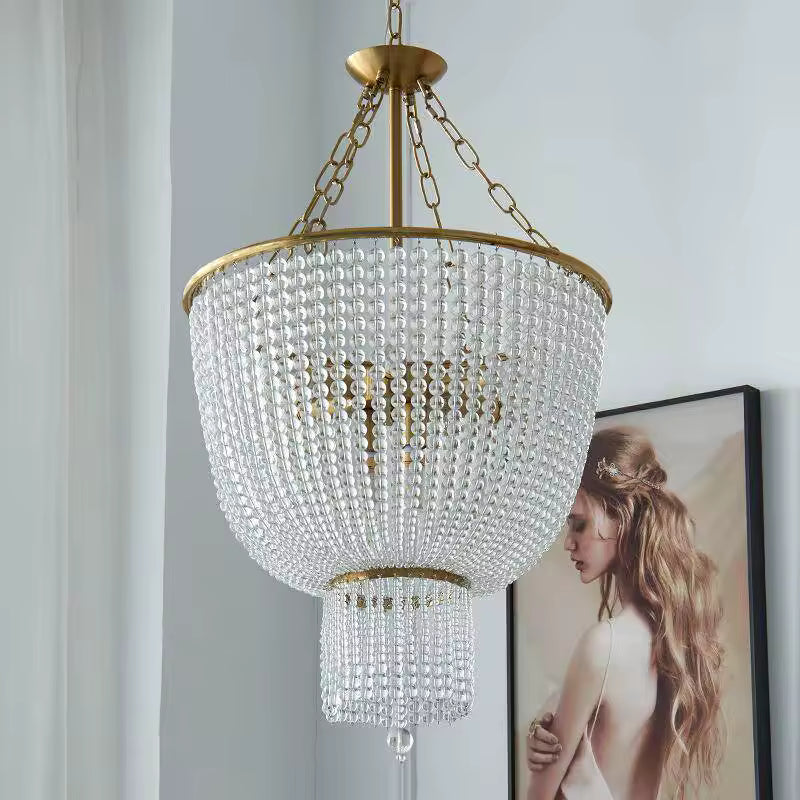 Lustre perle en cascade au style Art déco, orné de rangées de perles transparentes et d'une structure dorée.