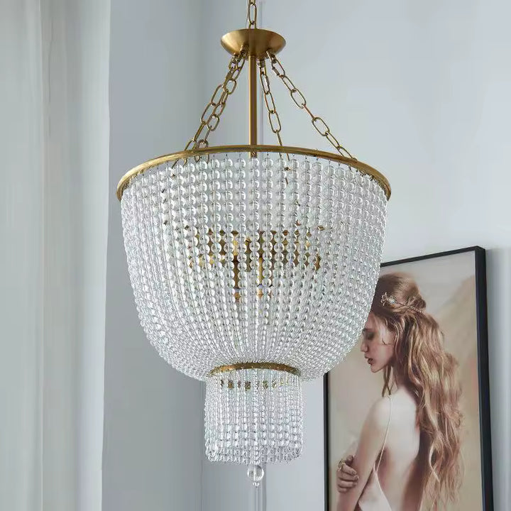 Lustre perle en cascade au style Art déco, orné de rangées de perles transparentes et d'une structure dorée.