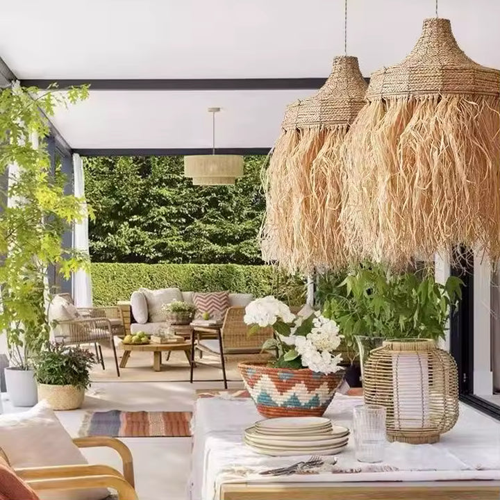 Lustre raphia à longues franges dans une terrasse couverte au décor bohème, végétal et naturel
