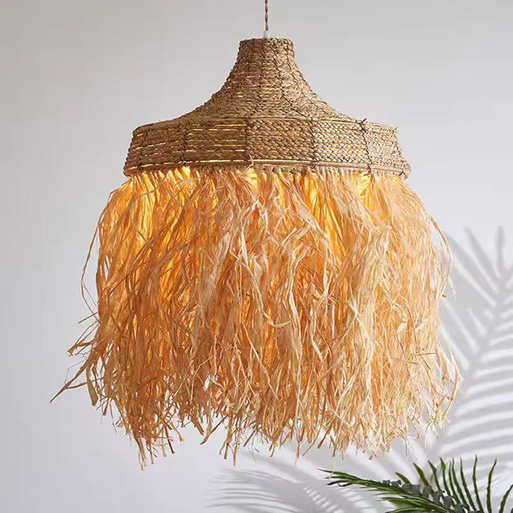 Lustre raphia à longues franges éclairées d’une lumière chaude, au style bohème, naturel et balinais.