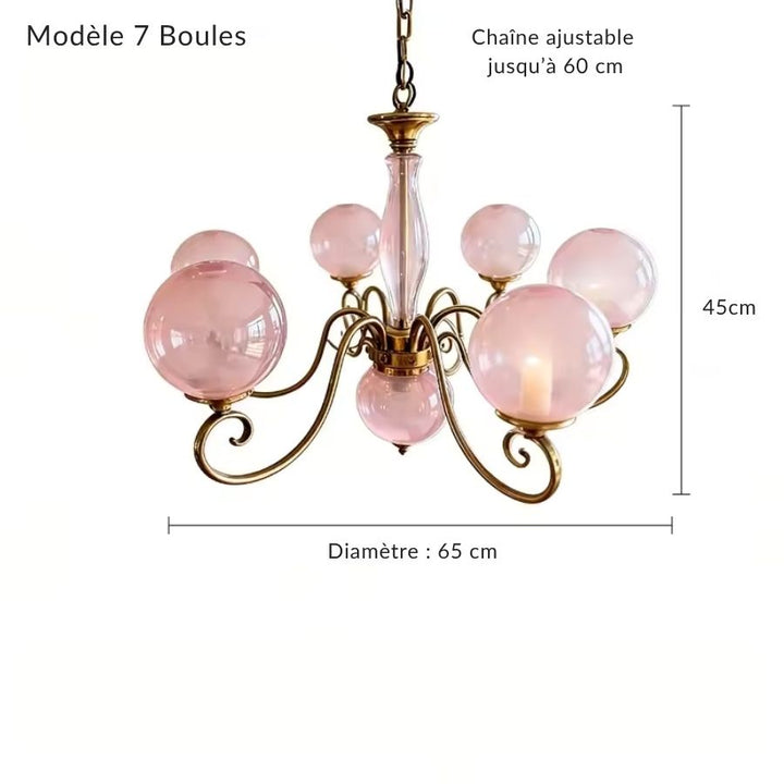 Lustre rose à 7 boules en verre sur volutes dorées, au style baroque élégant et généreusement décoratif