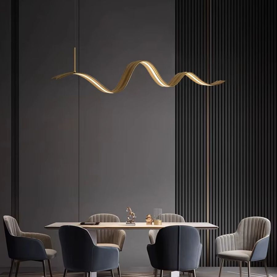 Au-dessus d’une table contemporaine, le lustre ruban LED doré apporte une ligne fluide au décor minimaliste