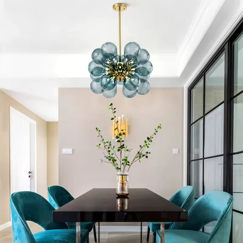 Au-dessus d'une table à manger, lustre sculptural à 18 globes en verre bleu fumé et métal doré au style rétro design.