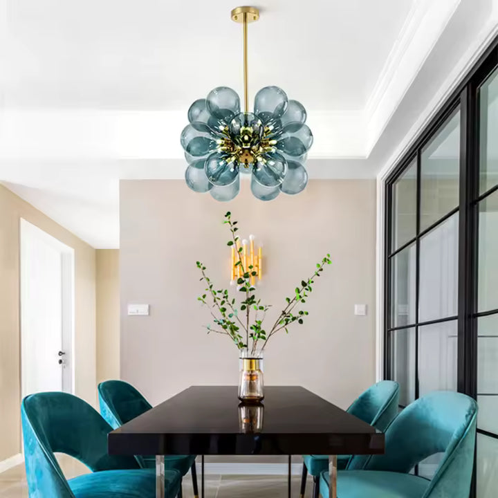 Au-dessus d'une table à manger, lustre sculptural à 18 globes en verre bleu fumé et métal doré au style rétro design.