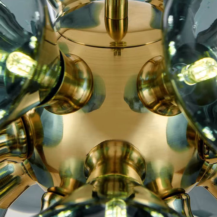 Détail de la structure centrale en métal doré brillant d'un lustre sculptural, avec globes en verre bleu fumé et LED.