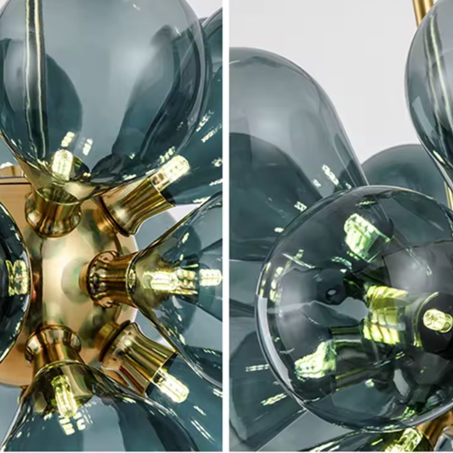 Gros plan sur les globes en verre bleu fumé et les finitions dorées d'un lustre sculptural au design rétro années 70.