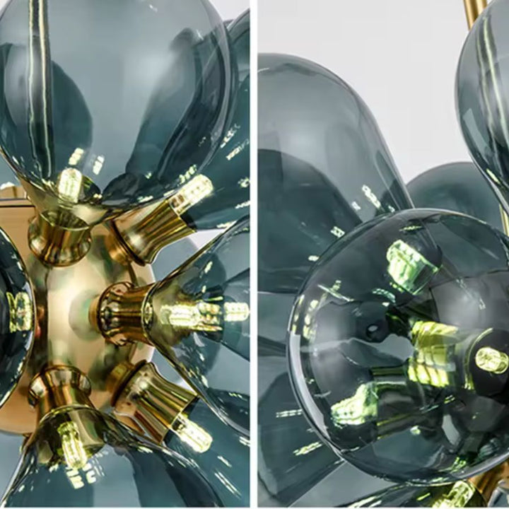 Gros plan sur les globes en verre bleu fumé et les finitions dorées d'un lustre sculptural au design rétro années 70.