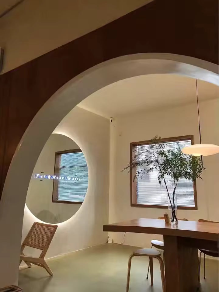 Lustre soucoupe blanc au style organique et contemporain, suspendu dans une salle à manger aux lignes courbes