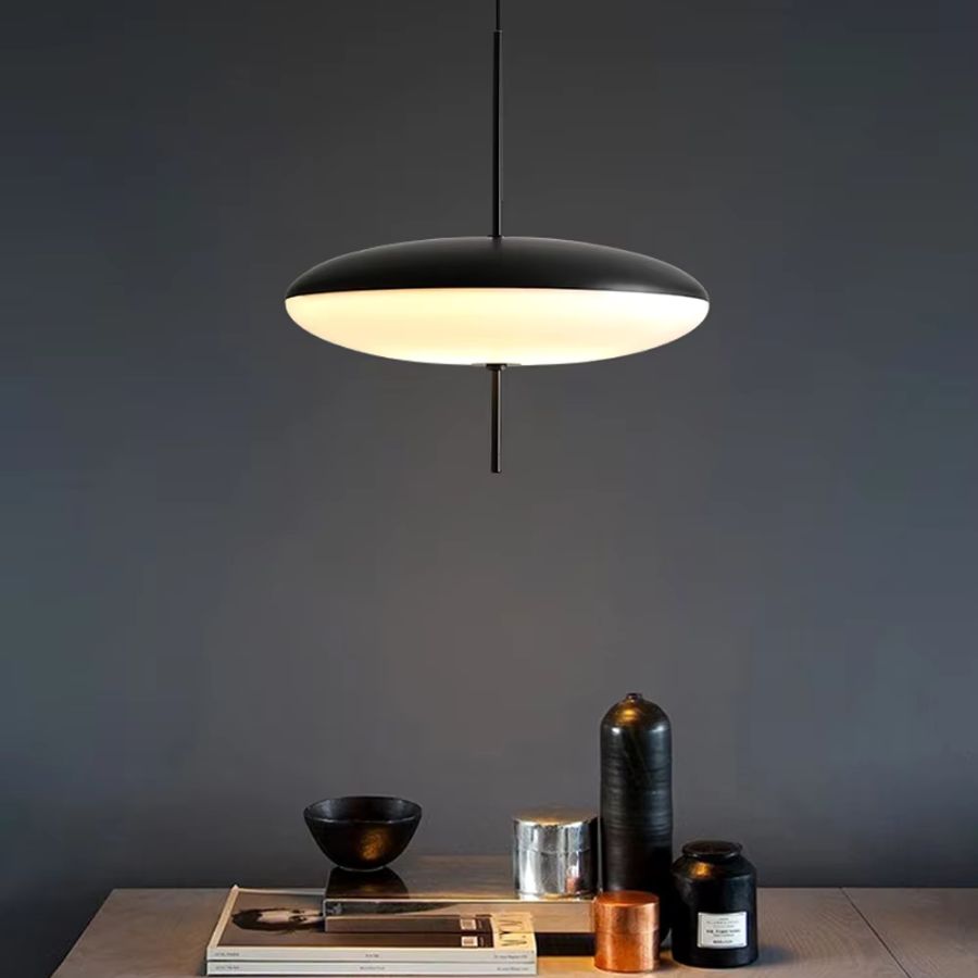 Lustre soucoupe noir et blanche en acrylique au design futuriste et épuré, suspendu au-dessus d’une table contemporaine