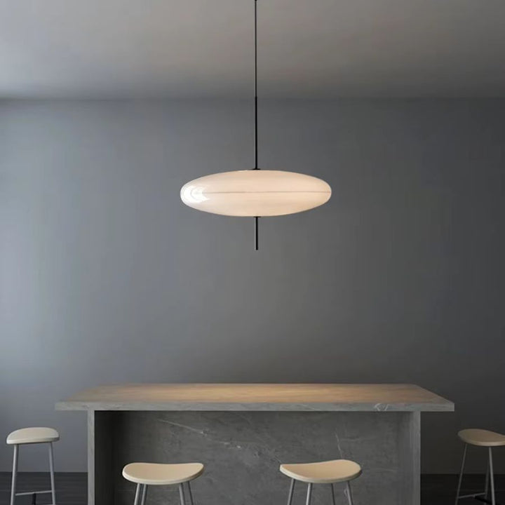 Lustre soucoupe blanche au design contemporain et épuré, suspendu au-dessus d’un îlot central