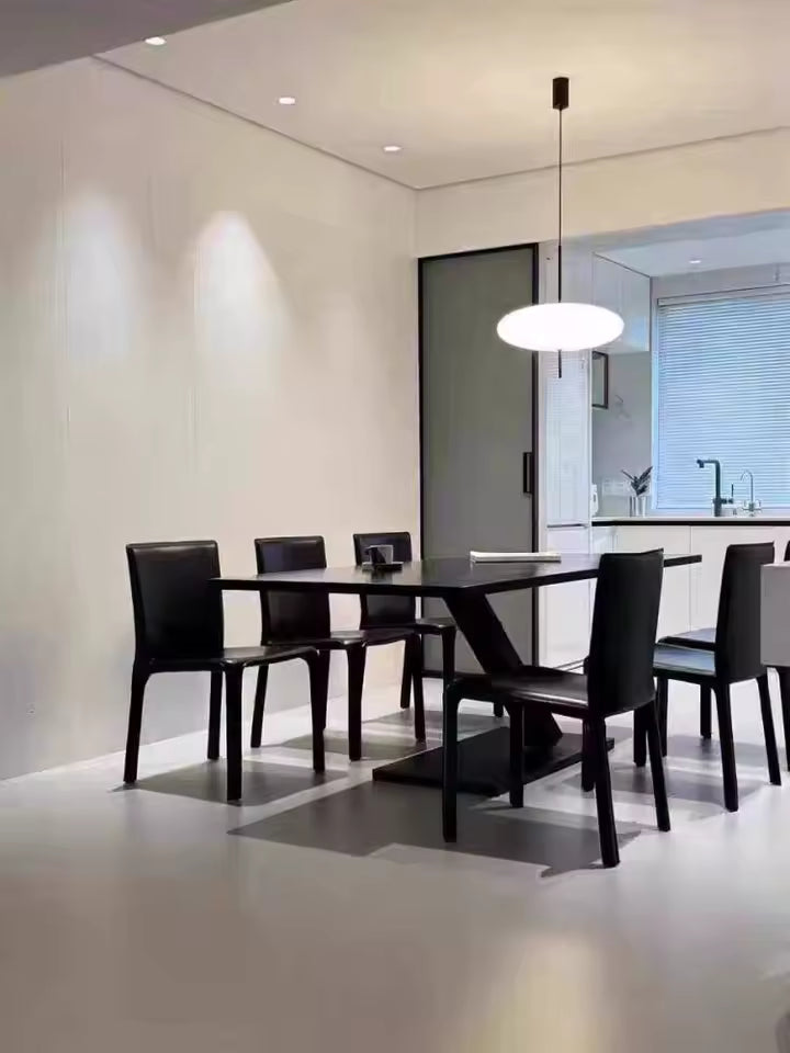 Lustre soucoupe blanc au design minimaliste, suspendu au-dessus d’une table dans une salle à manger moderne