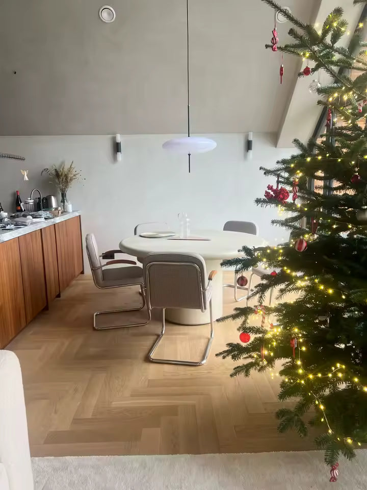 Lustre soucoupe blanc au style moderne et épuré, suspendu au-dessus d’une table ronde de salle à manger
