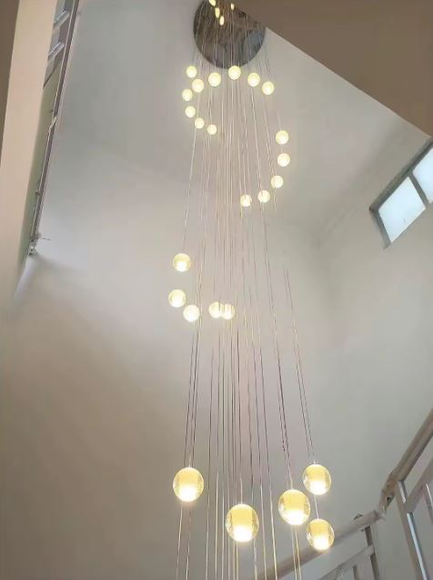 Lustre en spirale de globes en verre pour escalier, installation lumineuse aérienne idéale pour plafond très haut.