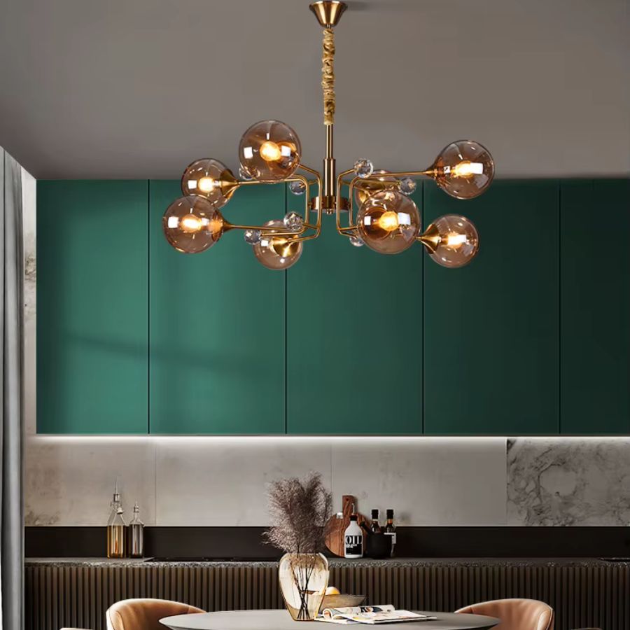 Lustre Spoutnik doré à 8 globes en verre ambré, au style Mid-Century, suspendu dans une salle à manger vert émeraude.