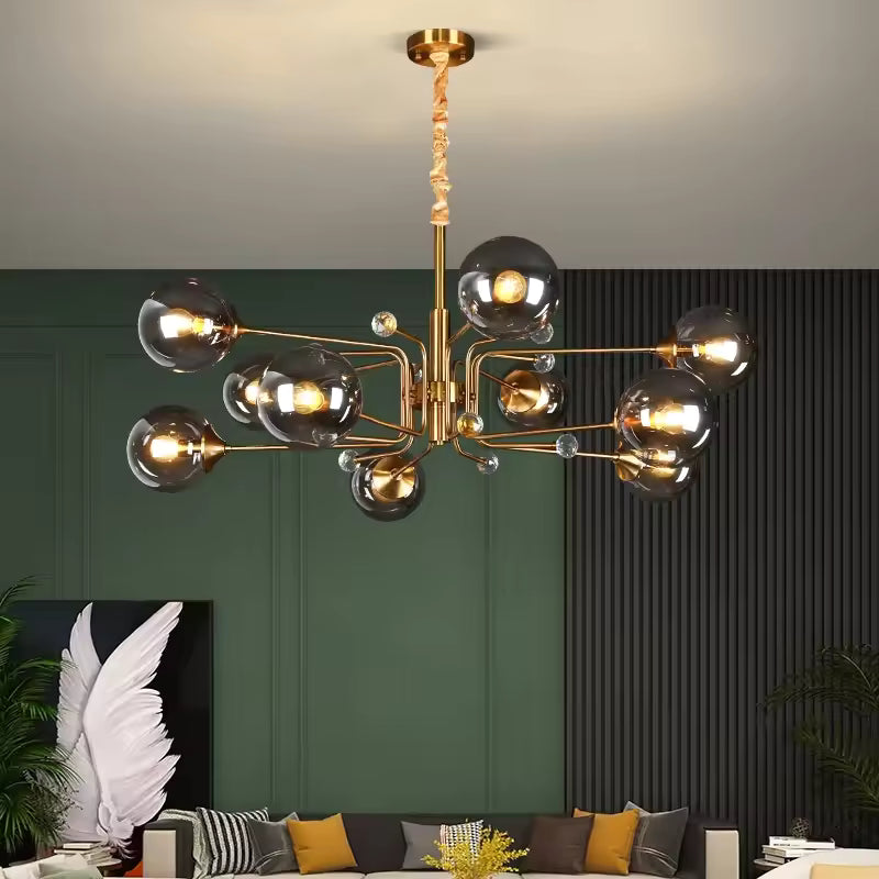 Dans un salon vert foncé, lustre Spoutnik doré aux globes en verre fumé, inspiré du design atomique des années 60.